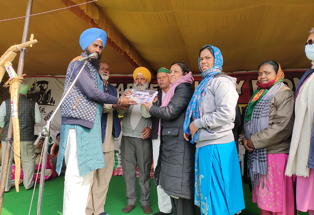 Presentation Sr. Dorothy Fernandes (in black coat), national secretary of the Forum for Justice and Peace, presents signatures she collected from her base in Patna in eastern India to support the farmers’ protests in Delhi. (Courtesy of Dorothy Fernandes)