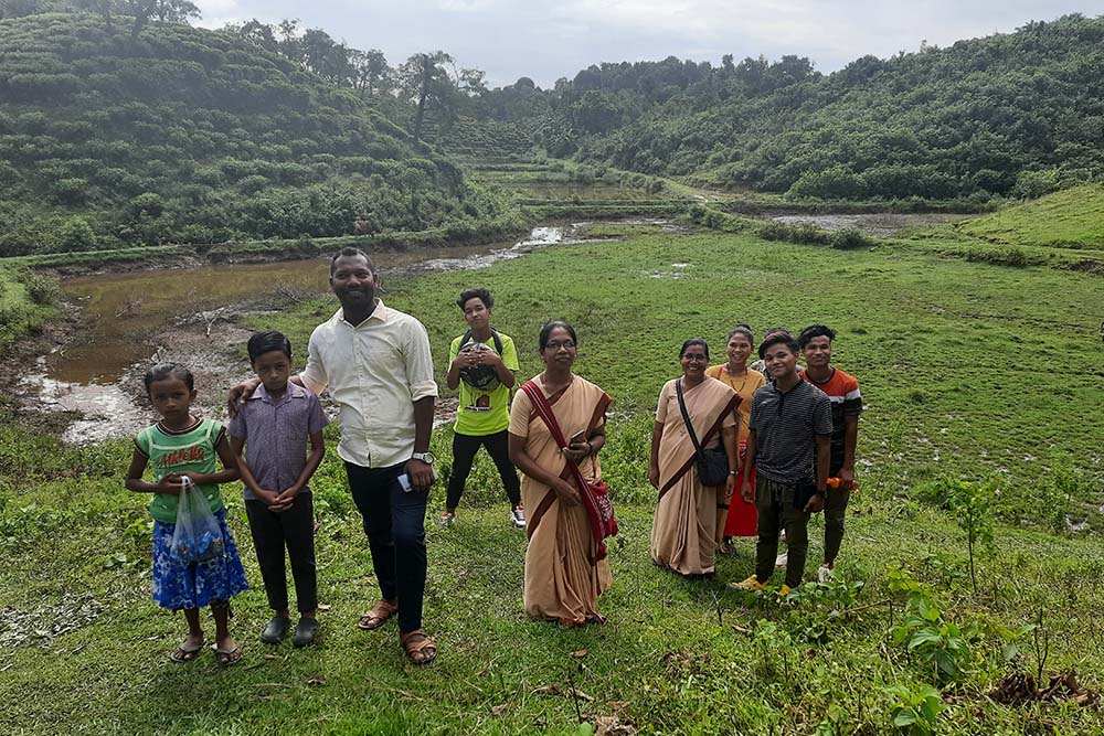 Fr. Michael Toppo (left), Sister Leema (center), Sr. Frida Toppo (right) and some of the children who board at the Nirmala children's home run by the sisters (Courtesy of Frida Toppo)