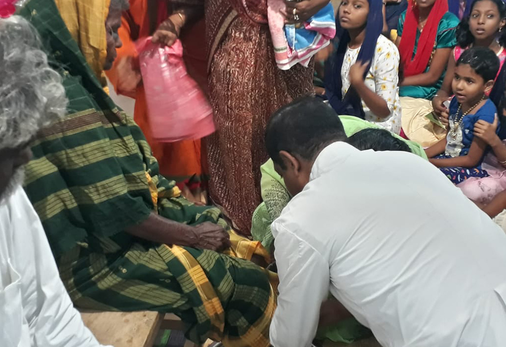 Fr. Anthony Packiam, parish priest of Christ the King church in Madurai in the southern Indian state of Tamil Nadu, washes a woman's feet on Holy Thursday 2022. (Courtesy of Sujata Jena)