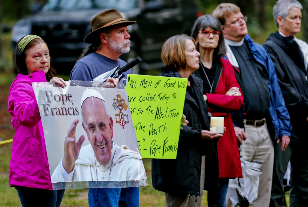 Death penalty opponents hold posters referring to Pope Francis as they stand outside the Georgia Diagnostic Prison in Jackson before the execution of Kelly Gissendaner by lethal injection in 2015. (CNS/EPA/Erik S. Lesser)