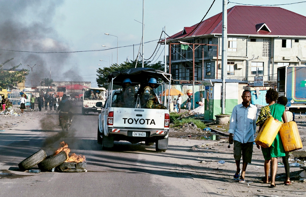 Peacekeepers drive past burning tires as they patrol protests against President Joseph Kabila in Kinshasa, Congo, April 10, 2017. (CNS/Reuters/Robert Carrubba)