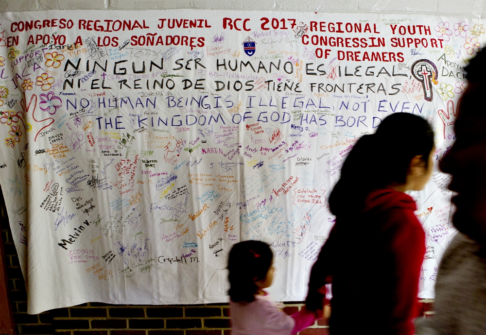 People walk in front of a banner supporting "Dreamers" during a daylong regional encuentro Oct. 28 at Herndon Middle School in Herndon, Virginia. (CNS/Tyler Orsburn) 