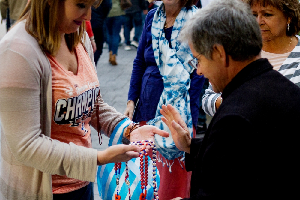 Fr. Paul Felix blesses rosaries Oct. 27 outside Houston's Annunciation Catholic Church, which sits across the street from Minute Maid Park where the Houston Astros hosted the Los Angeles Dodgers during the 2017 World Series. (CNS/Texas Catholic Herald)