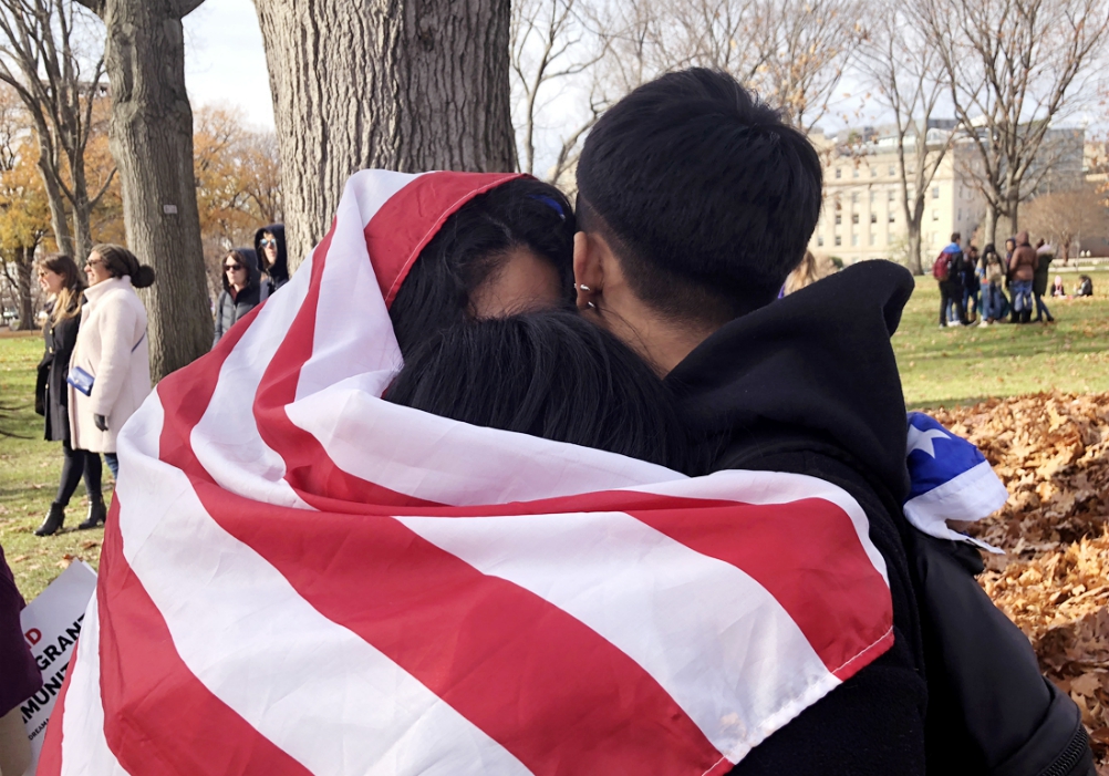 Young adults protect themselves from the cold by wrapping themselves in a U.S. flag near the U.S. Capitol during a rally Dec. 6, 2017, in support of undocumented immigrants. (CNS/Rhina Guidos)