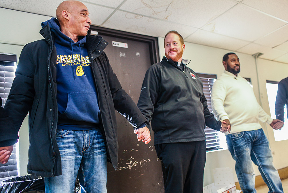 Fr. Matt O'Donnell, pastor of St. Columbanus Parish in Chicago, prays with volunteers before they open the church's Wednesday food pantry in a file photo. In 2020, the church received an estimated $70,000 in Paycheck Protection Program loans. (CNS) Fr. Matt O'Donnell, pastor of St. Columbanus Parish in Chicago, prays with volunteers before they open the church's Wednesday food pantry in a file photo. In 2020, the church received an estimated $70,000 in Paycheck Protection Program loans. (CNS)