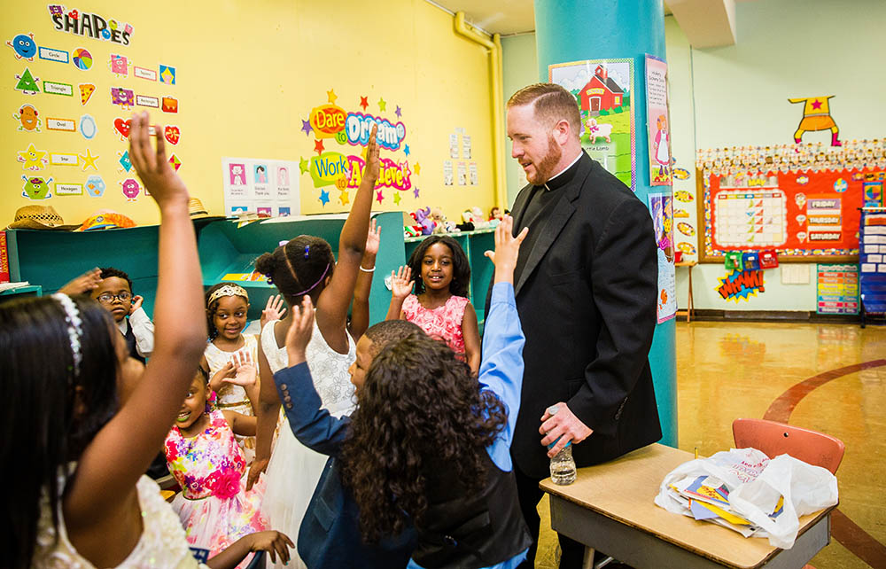 Fr. Matt O'Donnell, pastor of St. Columbanus Parish on Chicago's South Side, talks with kindergarten students at Augustus Tolton Catholic Academy before their graduation ceremony in 2017. (CNS/Courtesy of Natalie Battaglia) Fr. Matt O'Donnell, pastor of St. Columbanus Parish on Chicago's South Side, talks with kindergarten students at Augustus Tolton Catholic Academy before their graduation ceremony in 2017. (CNS/Courtesy of Natalie Battaglia)