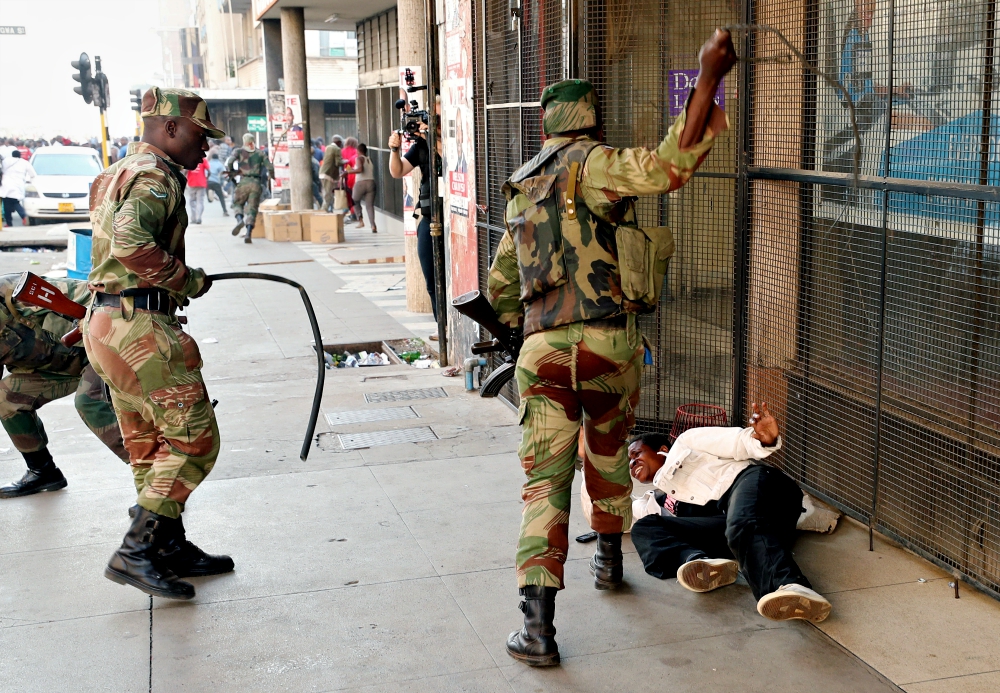Soldiers beat a female supporter of the MDC Alliance opposition party of Nelson Chamisa outside the party's headquarters as they await the results of the general elections Aug. 1 in Harare, Zimbabwe. (CNS/Reuters/Mike Hutchings) Soldiers beat a female supporter of the MDC Alliance opposition party of Nelson Chamisa outside the party's headquarters as they await the results of the general elections Aug. 1 in Harare, Zimbabwe. (CNS/Reuters/Mike Hutchings)