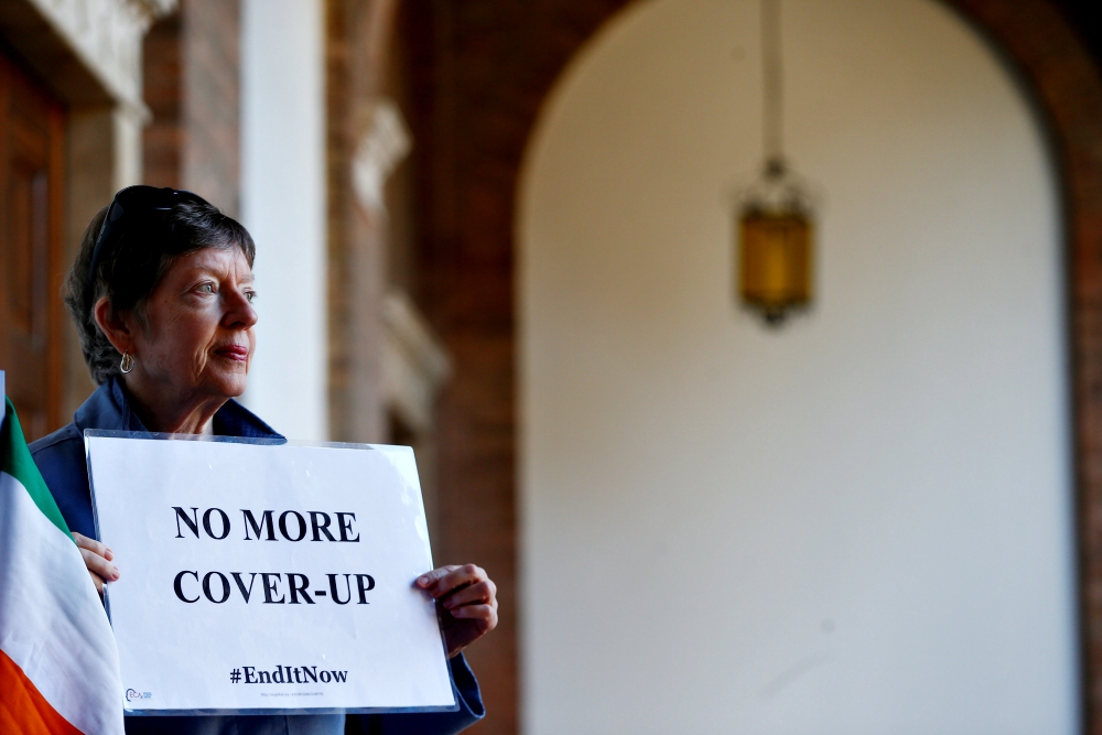 A woman demonstrates inside the headquarters of the Benedictine order in Rome Feb. 22 during a four-day meeting on the protection of minors in the church at the Vatican. (CNS/Reuters/Yara Nardi)