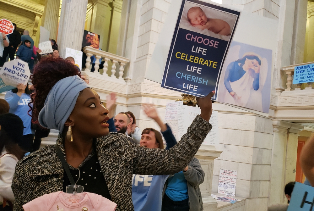 Elizabeth Koroma of Providence, Rhode Island, holds a pro-life sign in the rotunda of the Rhode Island Statehouse May 14 to protest a Senate bill aimed at expanding legal abortion in Rhode Island. The judiciary committee voted against the measure. (CNS) Elizabeth Koroma of Providence, Rhode Island, holds a pro-life sign in the rotunda of the Rhode Island Statehouse May 14 to protest a Senate bill aimed at expanding legal abortion in Rhode Island. The judiciary committee voted against the measure. (CNS)
