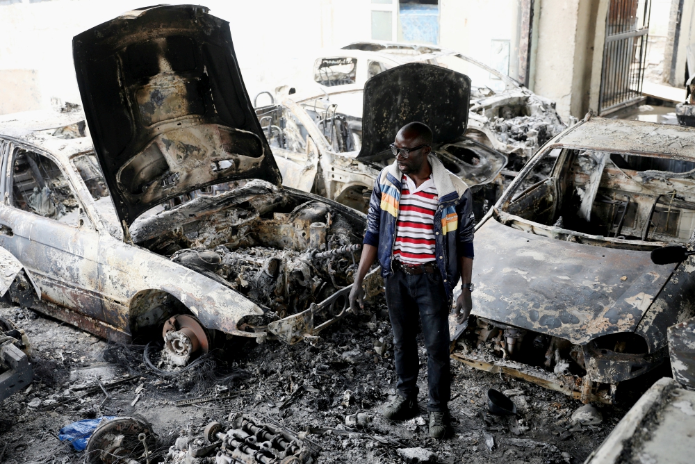 Nigerian entrepreneur Basil Onibo, one of the victims of a recent spate of xenophobic attacks in South Africa, looks at the burned cars at his dealership in Johannesburg Sept. 5. (CNS/Reuters/Siphiwe Sibeko) Nigerian entrepreneur Basil Onibo, one of the victims of a recent spate of xenophobic attacks in South Africa, looks at the burned cars at his dealership in Johannesburg Sept. 5. (CNS/Reuters/Siphiwe Sibeko)