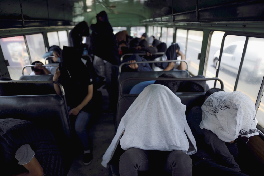 Guatemalan migrants cover themselves while on a bus outside La Aurora International Airport in Guatemala City March 19 after being deported from the U.S. (CNS/Reuters/Fabricio Alonso) Guatemalan migrants cover themselves while on a bus outside La Aurora International Airport in Guatemala City March 19 after being deported from the U.S. (CNS/Reuters/Fabricio Alonso)