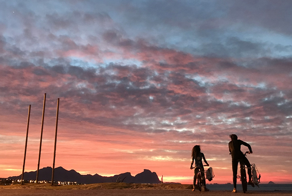 A father and his daughter are seen during a sunrise along a beach July 1, 2020, in Rio de Janeiro. Brazil is struggling to deal with the needs of more than 130,000 children who have been made orphans amid the COVID-19 pandemic. (CNS/Reuters/Sergio Morae