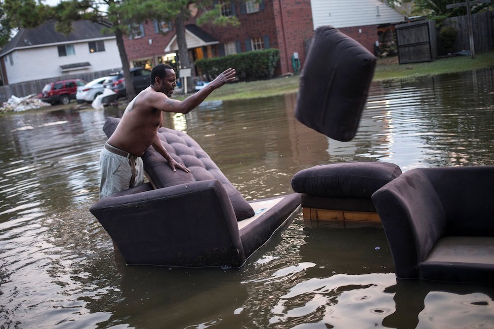 A man moves his flood-damaged sofas in Houston in the wake of Hurricane Harvey in 2017. Scientists say restoring and preserving wetlands could prevent millions of dollars' worth of damage from severe storms. (CNS photo/Adrees Latif, Reuters)