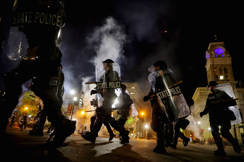 Police officers in Louisville, Kentucky, move past city hall Sept. 23 to clear protesters from a plaza ahead of a 9 p.m. curfew. (CNS/Reuters/Carlos Barria) Police officers in Louisville, Kentucky, move past city hall Sept. 23 to clear protesters from a plaza ahead of a 9 p.m. curfew. (CNS/Reuters/Carlos Barria)