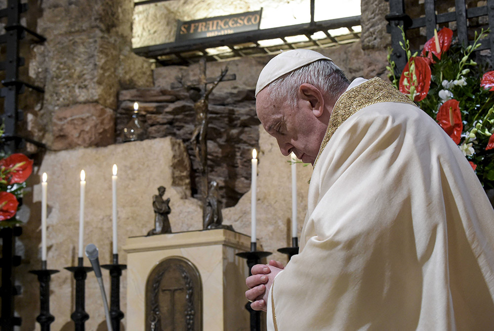 Pope Francis celebrates Mass at the tomb of St. Francis in the crypt of the Basilica of St. Francis Oct. 3 in Assisi, Italy. The pope signed his new encyclical, "Fratelli Tutti, on Fraternity and Social Friendship," at the end of the Mass. (CNS/Vatican Me