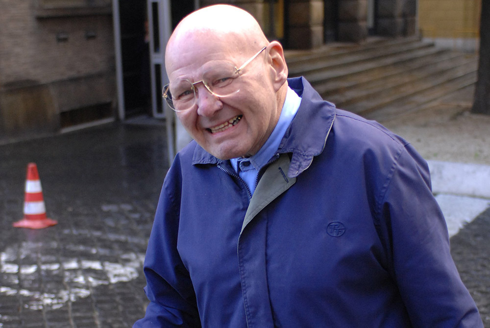 Wearing his trademark blue workman’s uniform, Discalced Carmelite Fr. Reginald Foster is photographed near the Vatican post office in this January 2007 file photo. (CNS/Chris Warde-Jones) Wearing his trademark blue workman’s uniform, Discalced Carmelite Fr. Reginald Foster is photographed near the Vatican post office in this January 2007 file photo. (CNS/Chris Warde-Jones)