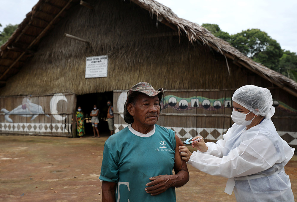 An Indigenous man receives the AstraZeneca/Oxford COVID-19 vaccine from a municipal health worker in the Sustainable Development Reserve of Tupe in Manaus, Brazil, Feb. 9. (CNS/Reuters/Bruno Kelly) An Indigenous man receives the AstraZeneca/Oxford COVID-19 vaccine from a municipal health worker in the Sustainable Development Reserve of Tupe in Manaus, Brazil, Feb. 9. (CNS/Reuters/Bruno Kelly)