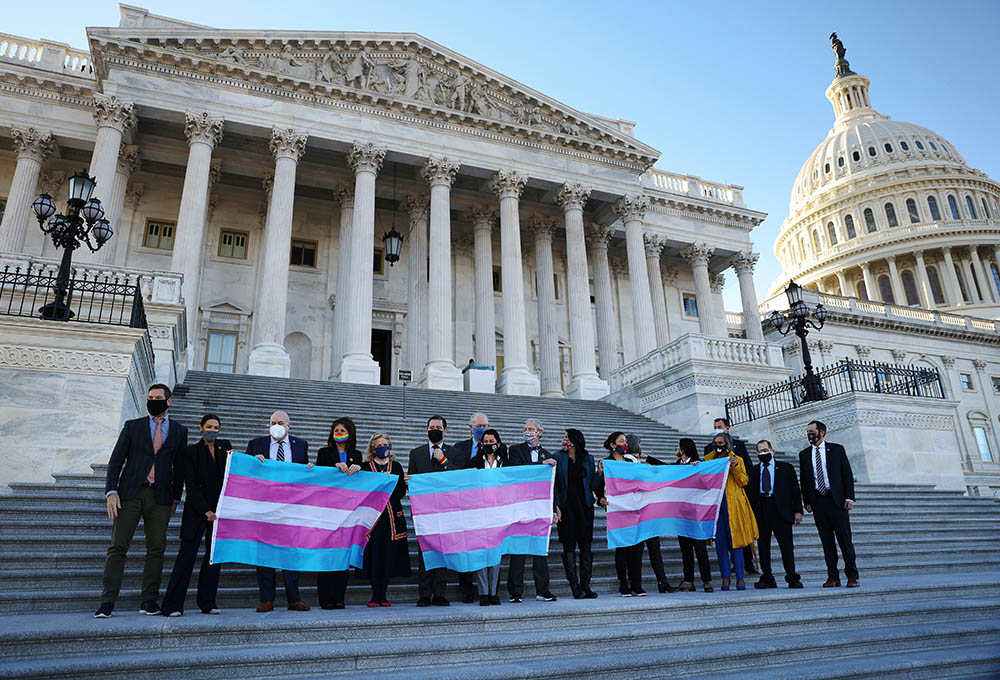 Democratic members of the U.S. House of Representatives pose for a photograph holding Transgender Pride flags on Capitol Hill in Washington Feb. 25, ahead of a vote on the Equality Act. (CNS/Reuters/Tom Brenner)