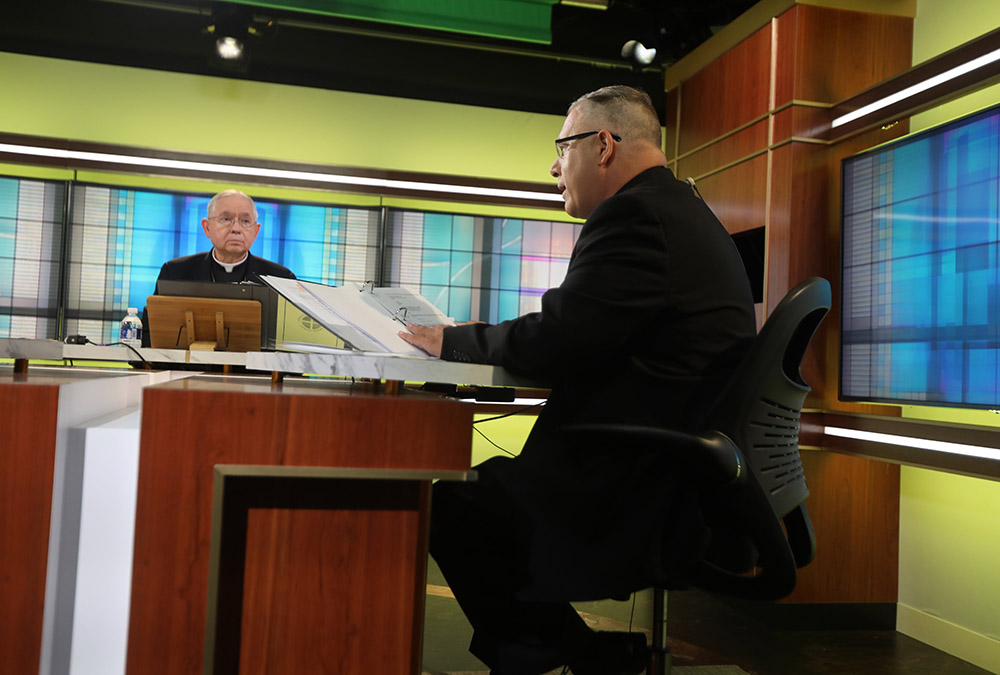 Los Angeles Archbishop José Gomez, president of the U.S. Conference of Catholic Bishops, looks on as Msgr. Jeffrey D. Burrill, the conference's general secretary, reads a message to Pope Francis June 16 at the conference headquarters in Washington. (CNS)