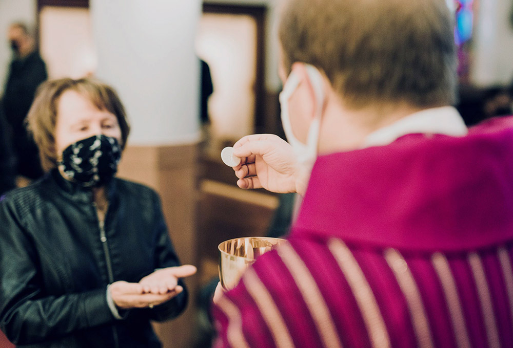 A woman receives Communion at St. John the Baptist Church in Monroe, Michigan, amid the coronavirus pandemic. (CNS/Courtesy of Detroit Catholic)