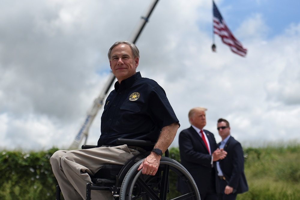 Texas Gov. Greg Abbott exits the stage with former President Donald Trump after a June 30 visit to an unfinished section of the wall along the U.S.-Mexico border in Pharr, Texas.