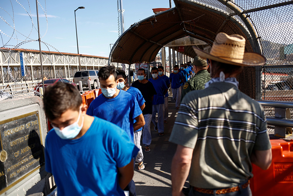 Migrants expelled from the U.S. and sent back to Mexico under Title 42 walk toward Mexico at the Paso del Norte International border bridge July 29, in this picture taken from Ciudad Juarez, Mexico. (CNS/Reuters/Jose Luis Gonzalez)