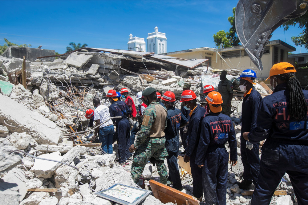 Members of a rescue and protection team clean debris from a house Aug. 15 in Les Cayes, Haiti, following a magnitude 7.2 earthquake the previous day. (CNS/Reuters/Ralph Tedy Erol)