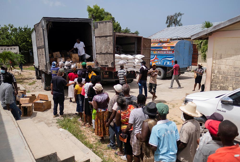 Earthquake victims wait in line for food provided by the World Food Program at a school in Port Salut, Haiti, Aug. 24. (CNS/Reuters/Ricardo Arduengo)