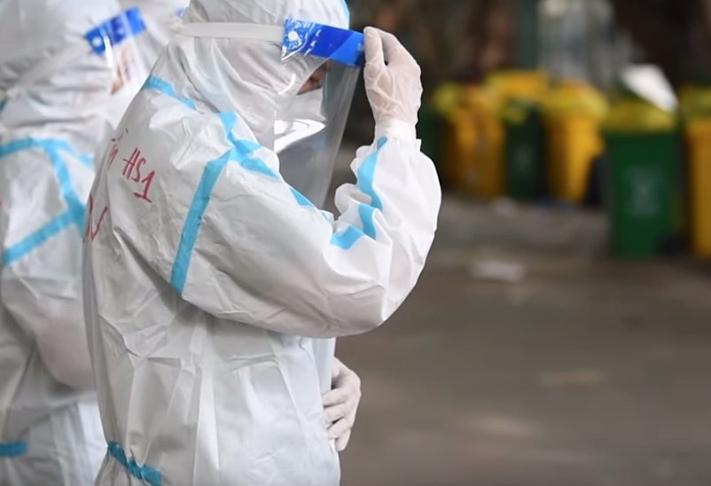 A screenshot from a video shows religious brothers and sisters in protective gear praying for deceased COVID-19 patients at a field hospital in Ho Chi Minh City, Vietnam.