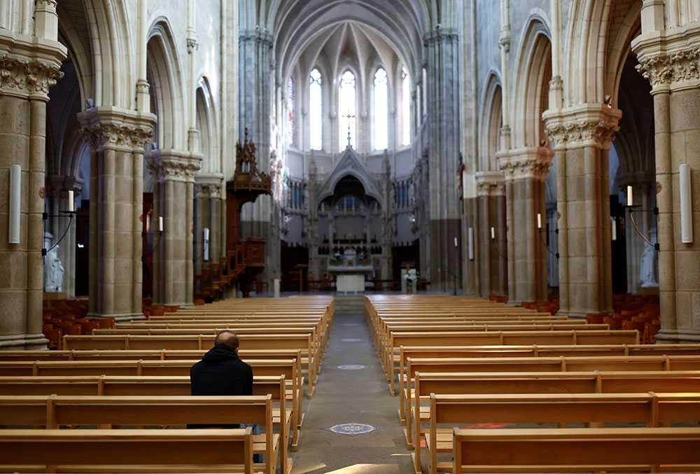 A man prays inside St. Martin Church near Nantes, France, Oct. 5. (CNS/Reuters/Stephane Mahe)