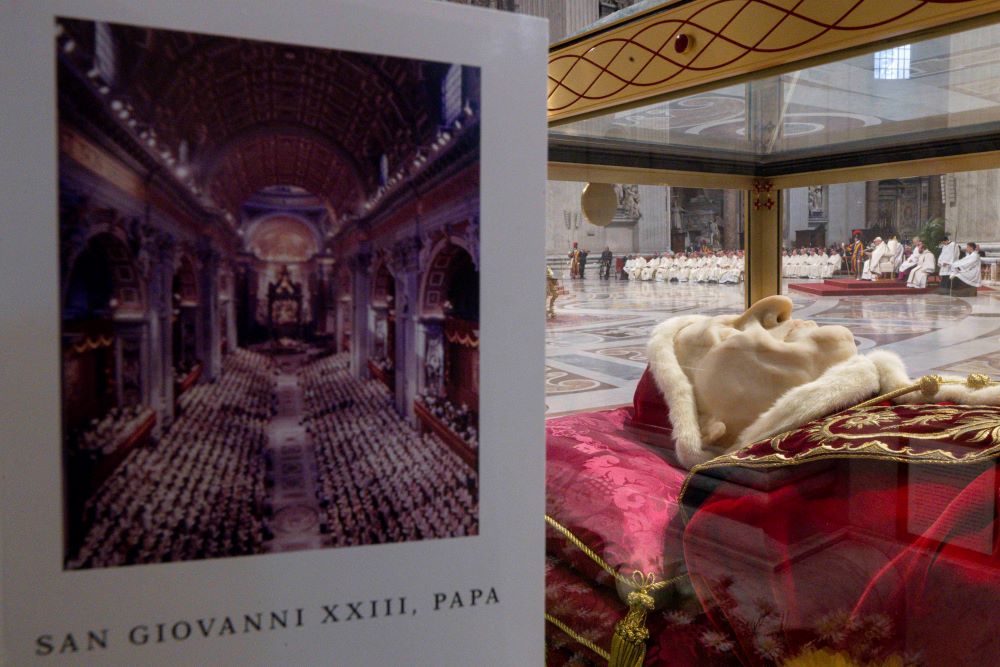 The program for the Mass celebrating the 60th anniversary of the opening of the Second Vatican Council and the feast of St. John XXIII is seen near a glass urn containing the body of the pope, who opened the council Oct. 11, 1962. (CNS/Vatican Media)