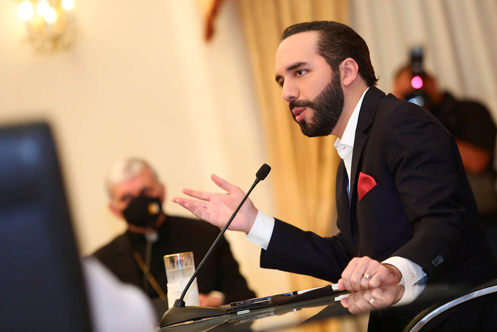 A prelate wearing a protective mask looks on as Salvadoran President Nayib Bukele takes part in a meeting at the Presidential House in San Salvador May 3, 2021. (CNS/Secretaria de Prensa de La Presidencia handout via Reuters)