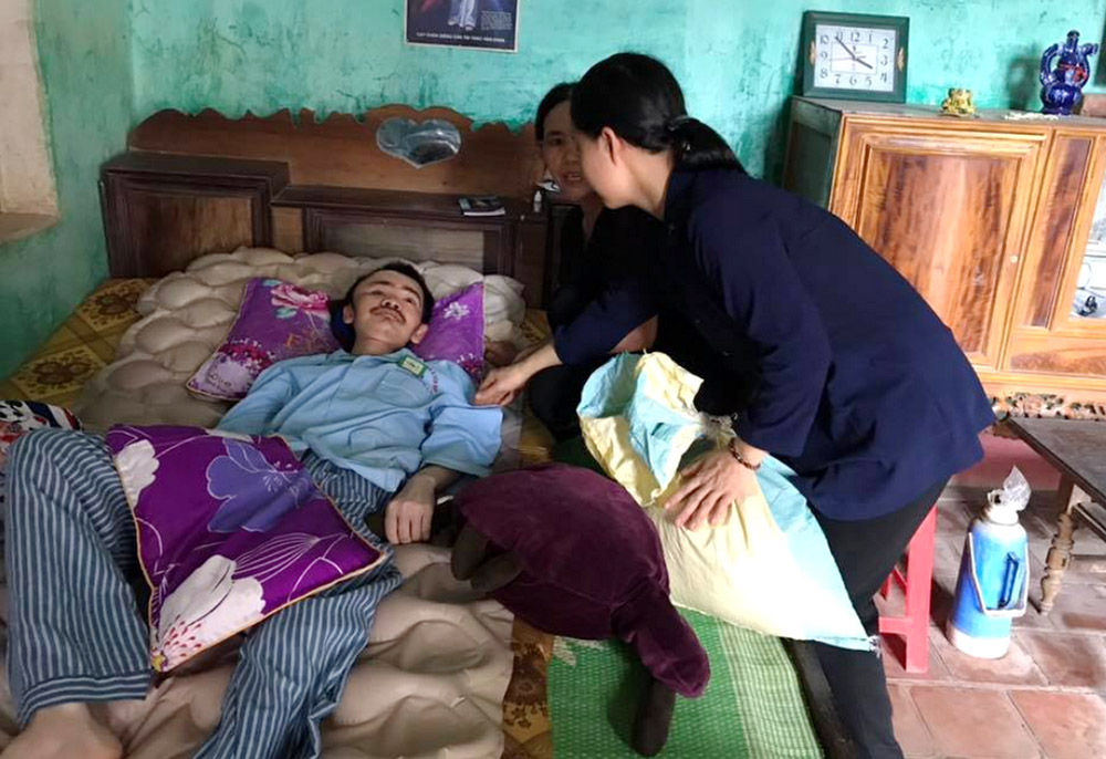 Daughters of Our Lady of the Visitation Sr. Mary Bonaventure Nguyen Thi Thien (second from right) and another sister visit Bartholomew Tran Dao The at his home Aug. 6. (GSR photo/Joachim Pham)