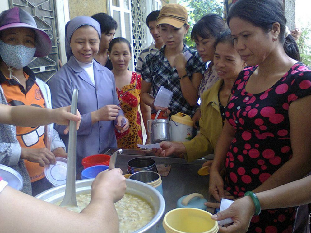 Patients and their relatives receive chao from St. Paul de Chartres sisters in Hue, Vietnam, Aug. 9. (GSR photo/Joachim Pham)