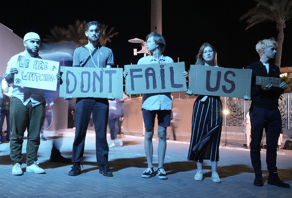 Activists hold signs at the COP27 U.N. Climate Summit on Nov. 19 in Sharm el-Sheikh, Egypt. (AP/Nariman El-Mofty)