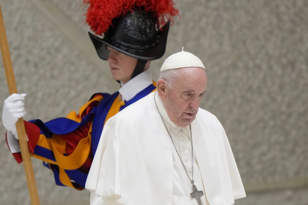 Pope Francis walks past a Vatican Swiss Guard