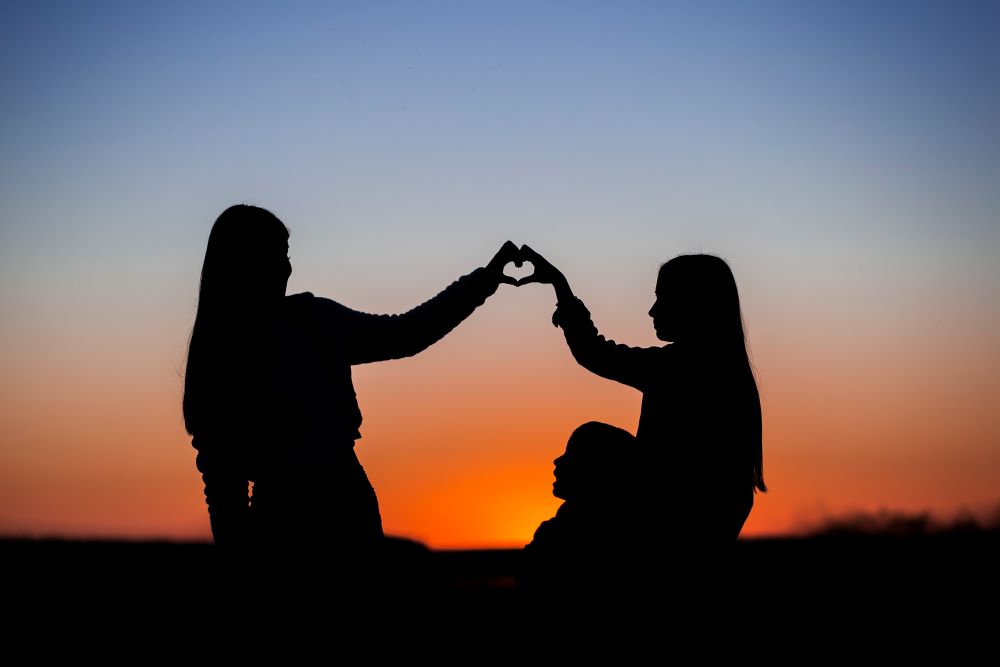 Girls form heart with their fingers