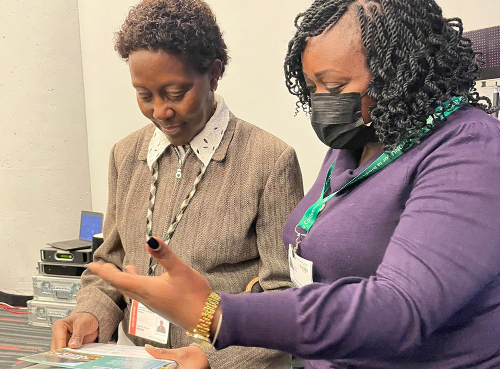 Caroline Kiiru (right), biodiversity and climate change campaign manager for Laudato Si' Movement, presents a petition signed by 231,000 Catholics to Elizabeth Mrema, executive secretary of the U.N. Convention on Biological Diversity. (Courtesy of Laudato Si' Movement)