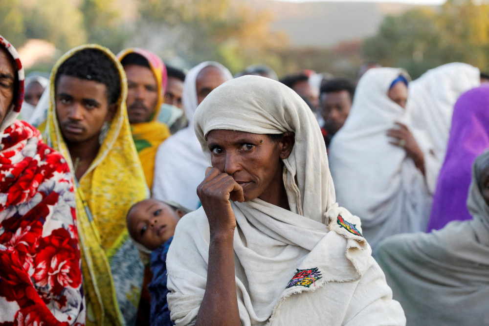 A woman stands in line to receive food donations at the Tsehaye primary school, which was turned into a temporary shelter for people displaced by conflict, in Shire, in Ethiopia's Tigray region. (CNS/Reuters/Baz Ratner)