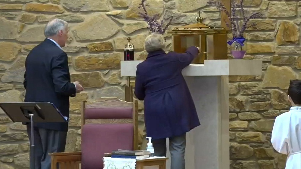 Extraordinary ministers of the Eucharist at St. John the Evangelist Church in Hydes, Maryland, repose the Eucharist in a donated tabernacle during Mass on April 3. (CNS/Catholic Review/Priscila González de Doran)