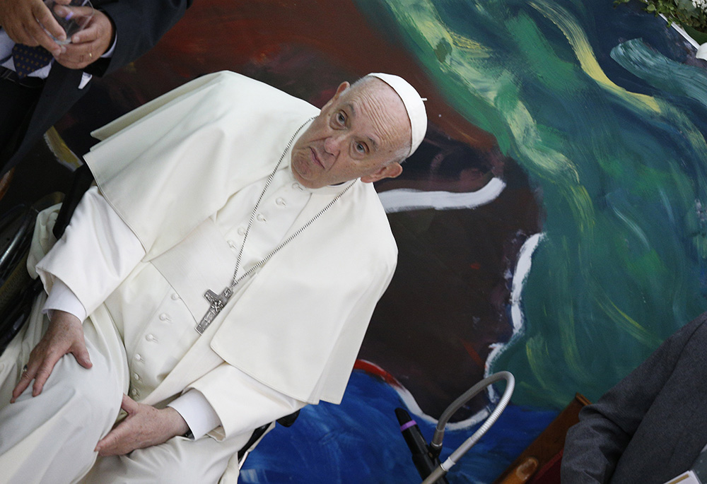 Pope Francis is pictured with his hands near his right knee in this photo shot accidentally during a meeting of Scholas Occurentes May 19 in Rome. The 85-year-old pope has been experiencing severe pain in his right knee for months. (CNS/Paul Haring)