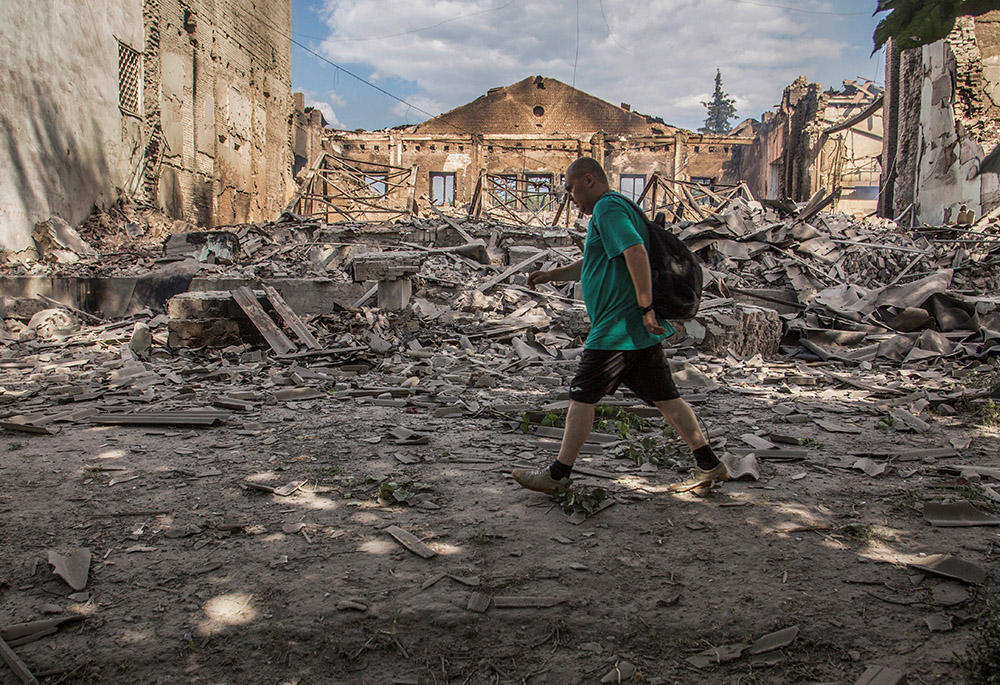 A local resident walks in a front of a building destroyed by a Russian military airstrike in a photo taken June 17 in Lysychansk, Ukraine. (CNS/Reuters/Oleksandr Ratushniak)