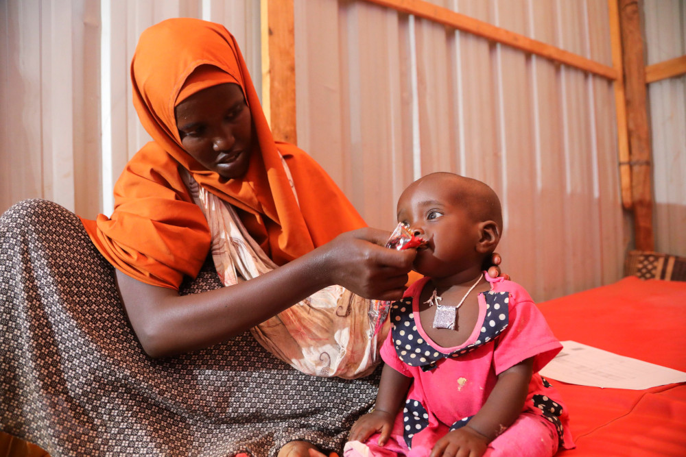 A displaced Somali woman feeds her child in a shelter during a severe drought near Dollow May 26. (CNS/Reuters/Feisal Omar)