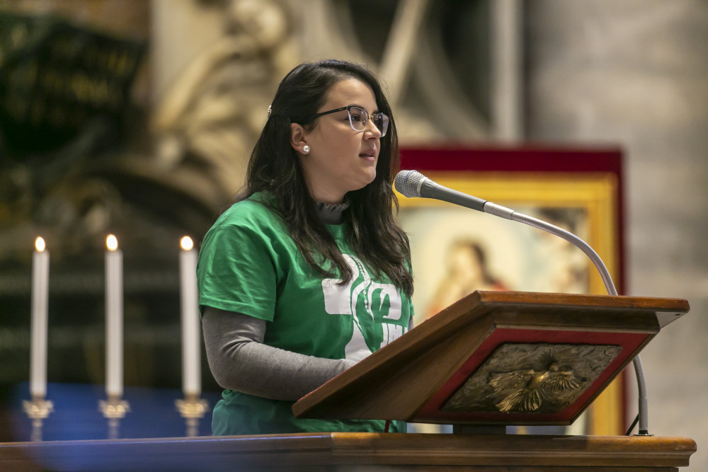 A young woman reads during Pope Francis' celebration of Mass on the feast of Christ the King in St. Peter's Basilica at the Vatican Nov. 22, 2020.