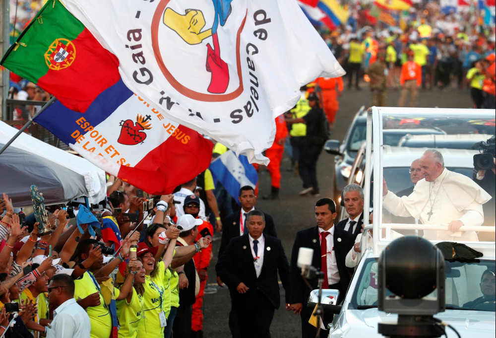 A Portuguese flag is seen near Pope Francis as he greets the crowd before celebrating Mass for World Youth Day pilgrims in Panama City