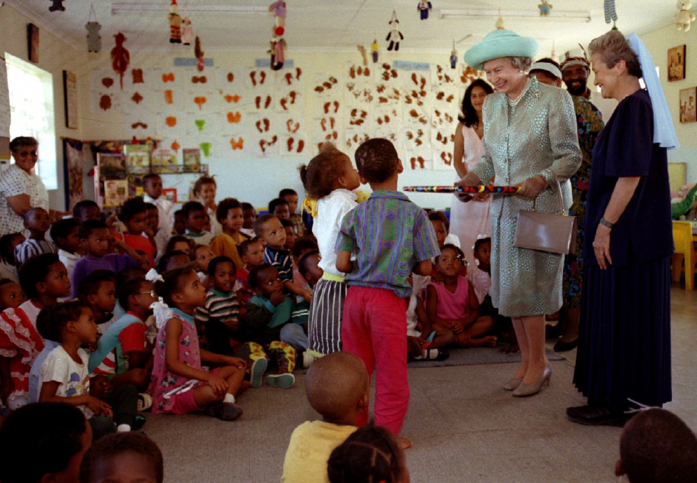 Britain's Queen Elizabeth II visits children at a clinic run by Sr. Ethel Normoyle, in New Brighton, South Africa in 1995