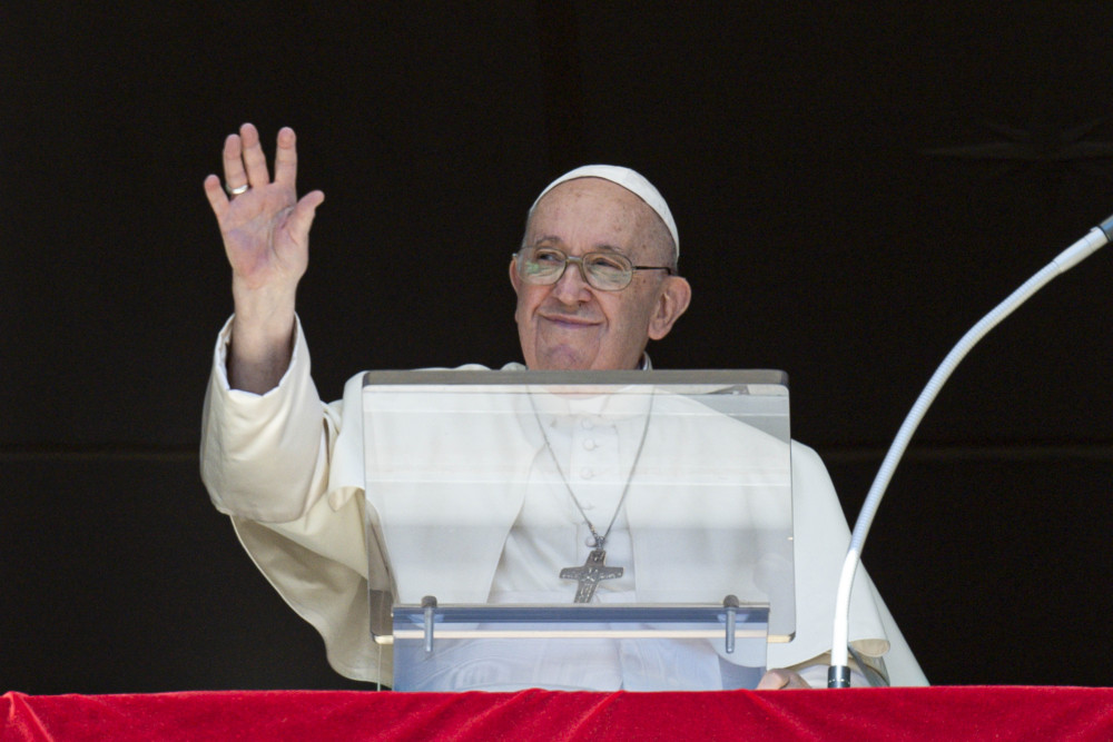 Pope Francis greets the crowd as he leads the Angelus from the window of his studio overlooking St. Peter's Square at the Vatican