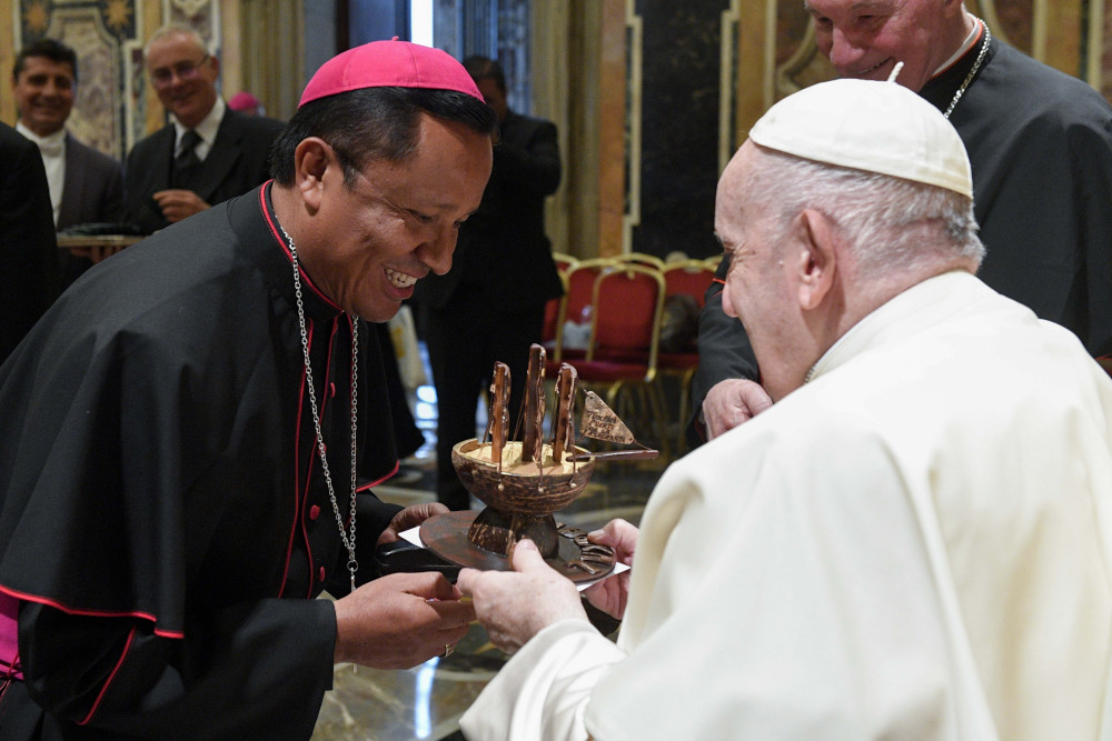 Pope Francis accepts a gift during an audience with almost 200 new bishops participating in a formation course