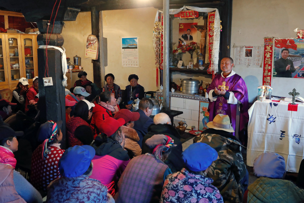 Posters of Chinese President Xi Jinping hang on the wall of the house of a Tibetan Catholic during a Mass celebrated by Father Yao Fei on Christmas Eve in Niuren village, in China's Yunnan province, in this Dec. 24, 2018, file photo. 