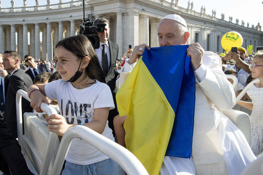 Pope Francis holds a Ukrainian flag as he greets the crowd before Mass in St. Peter's Square during the World Meeting of Families at the Vatican in this June 25, 2022, file photo.